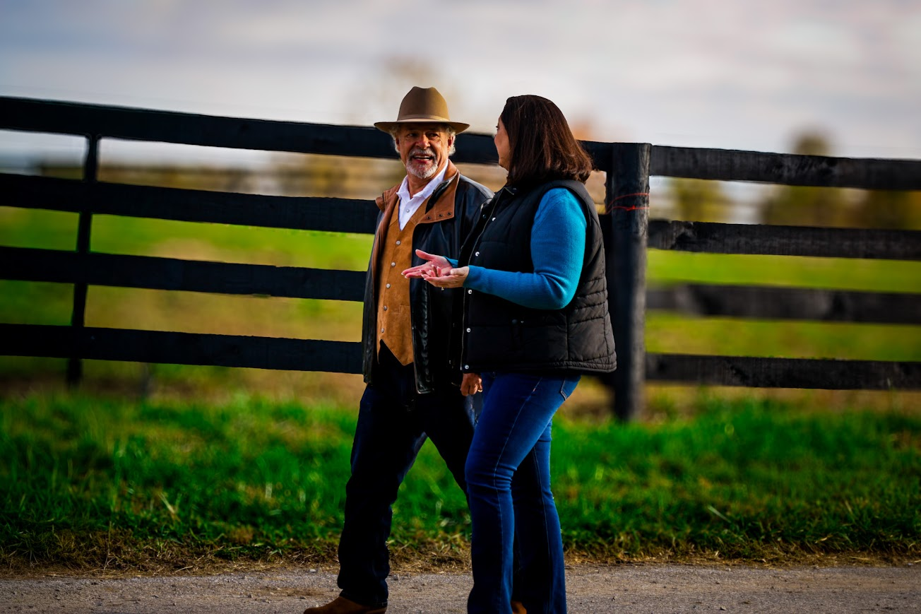 Couple walking along a Kentucky horse fence