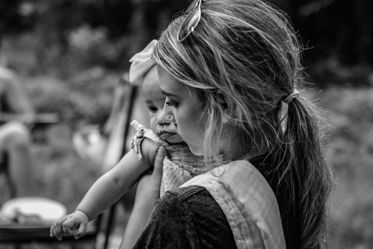 Sister holding baby — black & white